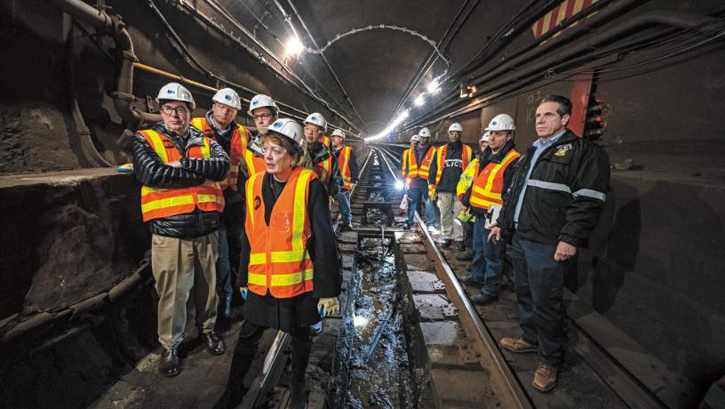A group of experts inspect the L train tunnel with Dean Mary C. Boyce and Gov. Andrew Cuomo in the foreground.