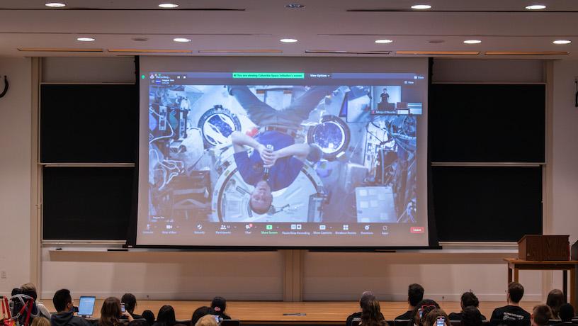 Students watch the screen of NASA Astronaut Warren Hoburg video calling form the ISS.