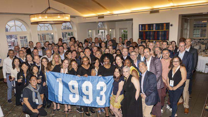 The Columbia Engineering class of 1993 alumni weekend attendees with a flag that reads "1993"