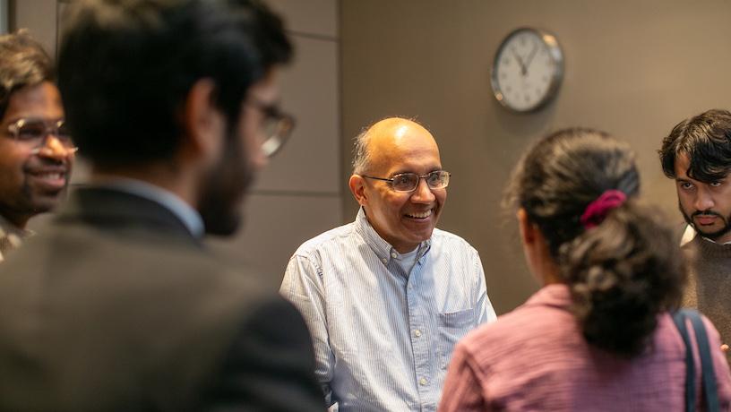 A smiling Rajesh Jain surrounded by four student attendees