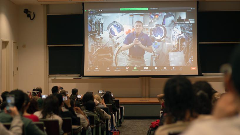 Students watch the screen of NASA Astronaut Warren Hoburg video calling from the ISS.