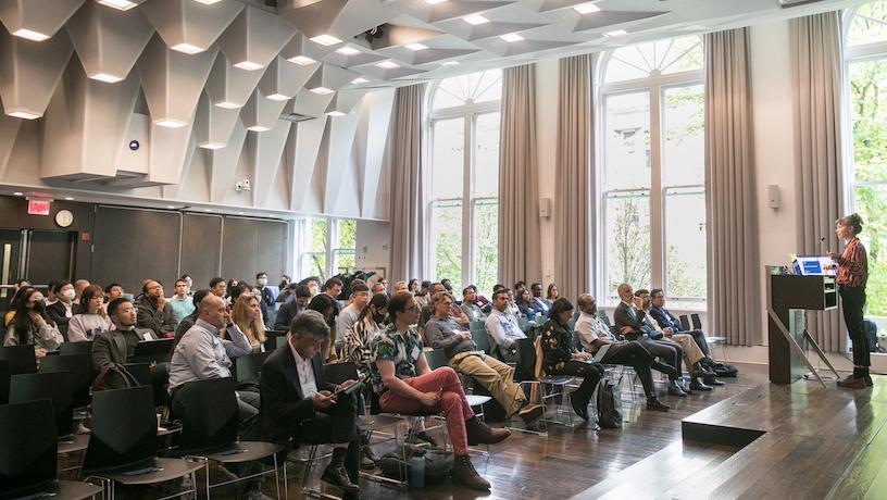 A speaker at the CAIT 2022 Symposium presents to an audience.
