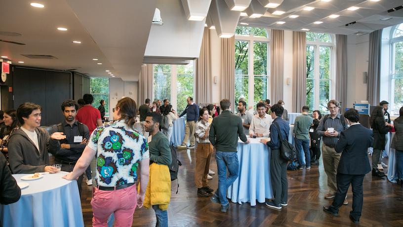 Attendees at the second annual CAIT symposium mingling at high-top tables.