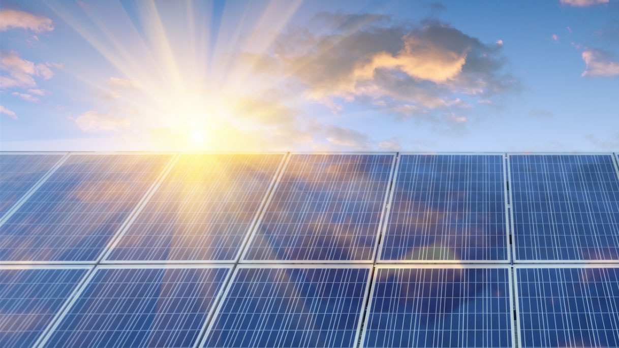 solar panels with the sun in background