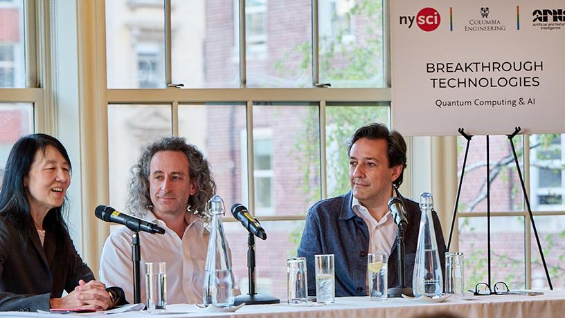 Three people at a table with microphones