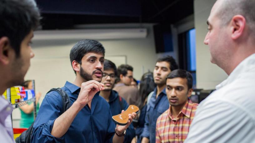 students discuss wearable device with judge