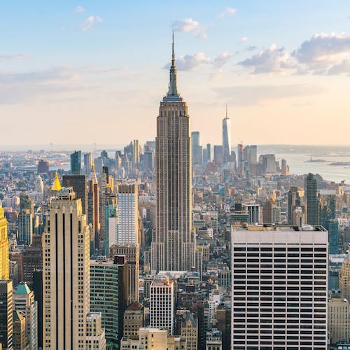 The Empire State Building towering over the New York City skyline during sunset