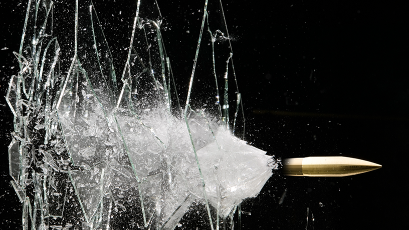 A bullet breaking through panes of glass