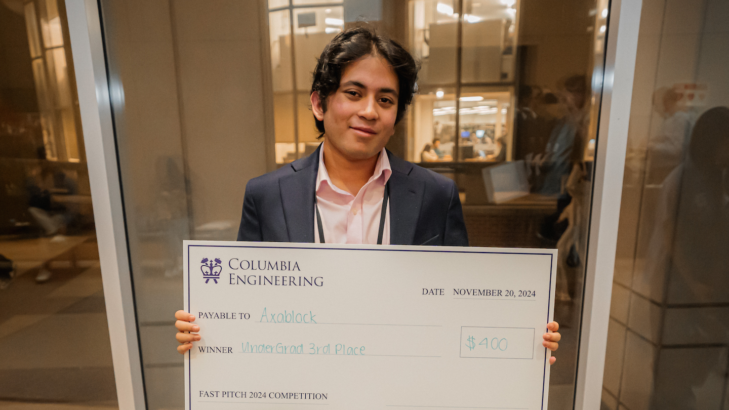 A student holding up a giant $400 check payable to Axablock