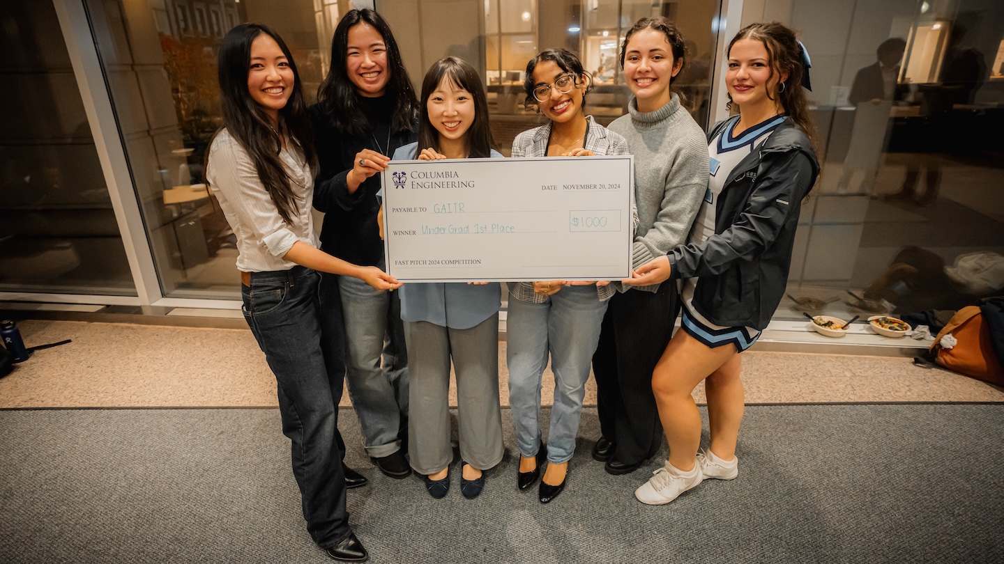 Six students holding up a giant $1,000 check payable to GAITR
