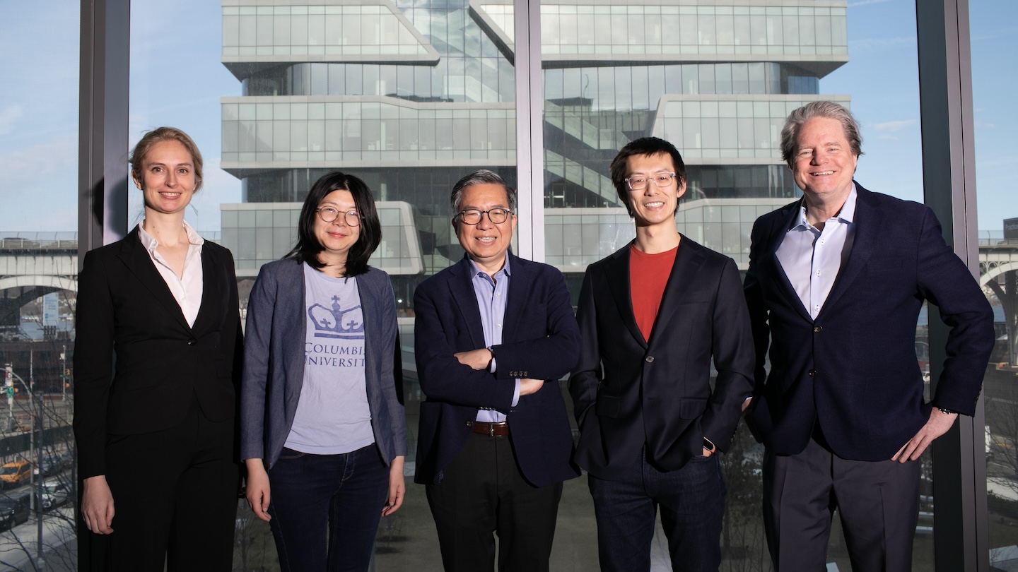 Five people posing for a photo in front Kravis Hall