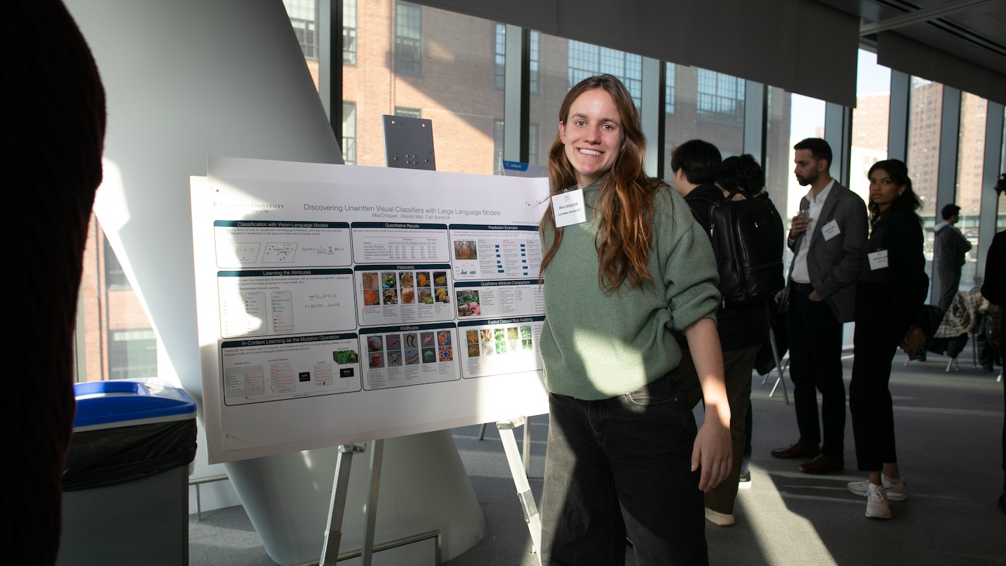 A woman smiling in front of a presentation board