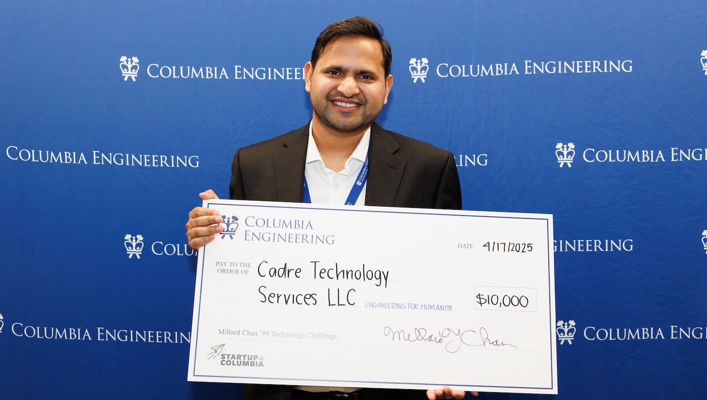 A smiling man holding a giant, $10,000 check addressed to Cadre Technology Services, LLC