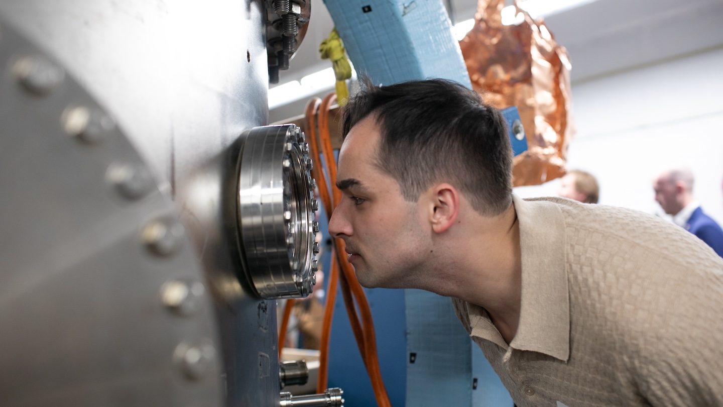 A person peers into a large metal machine