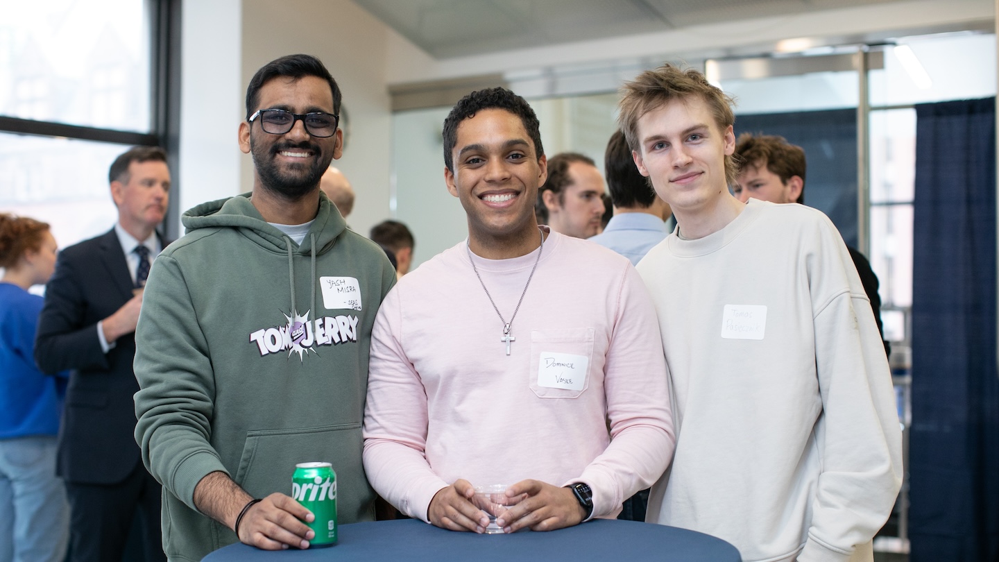 Three people wearing name tags posing for a photo