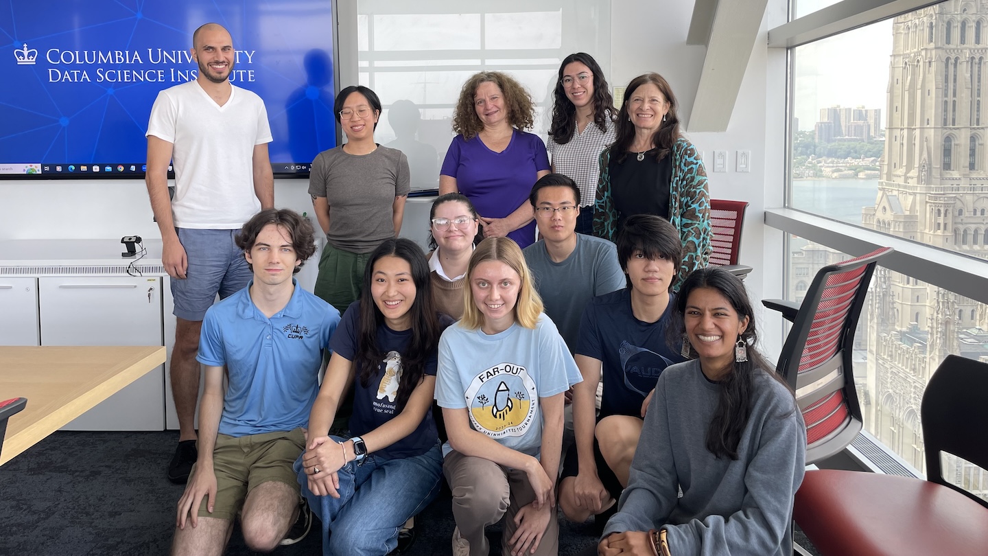 12 people posing for a photo in a classroom