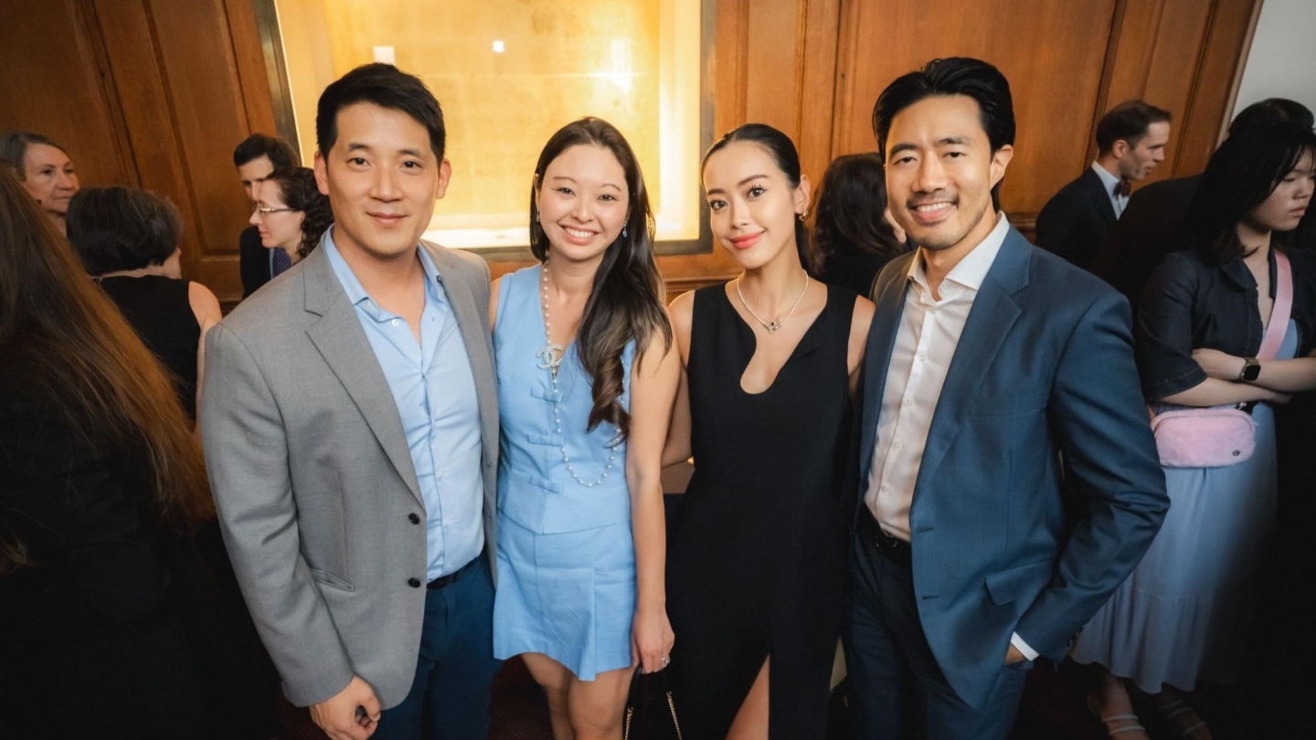 Four people dressed in semi-formal attire posing for a photo