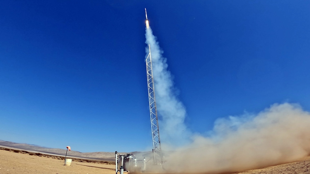 A rocket thrusting up into the blue a sky
