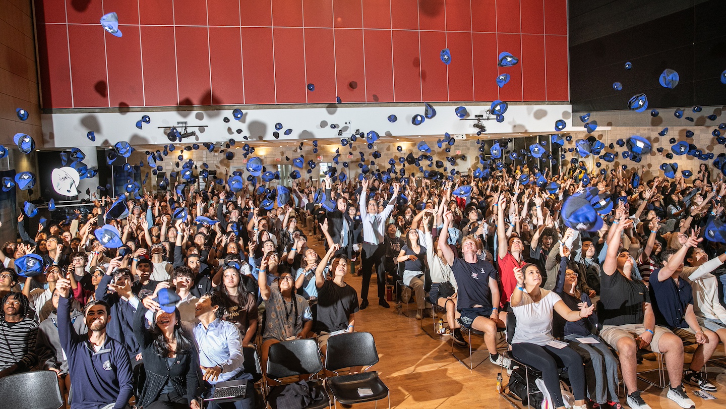 class throwing beanies in the air