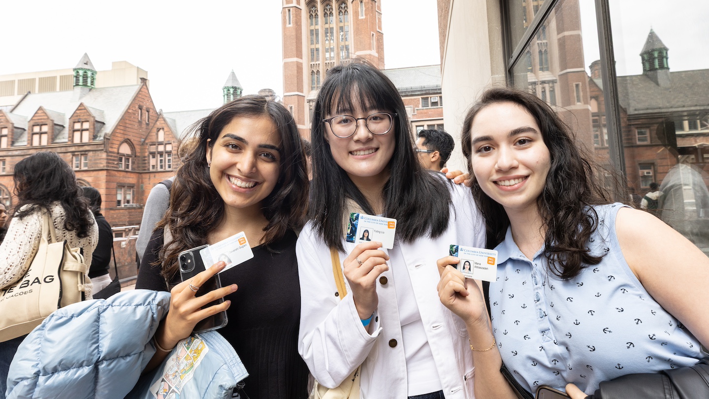 new students holding IDs