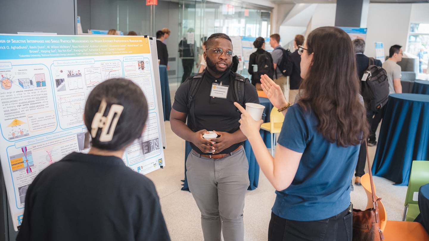 two participants speaking with a research presenter