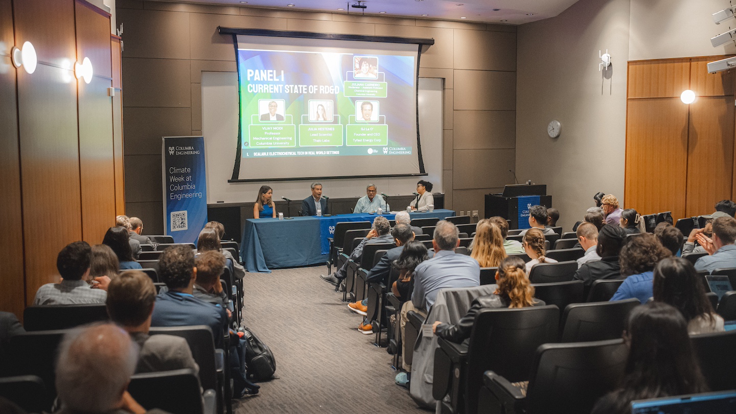 image of a lecture hall with audience members looking at a presentation