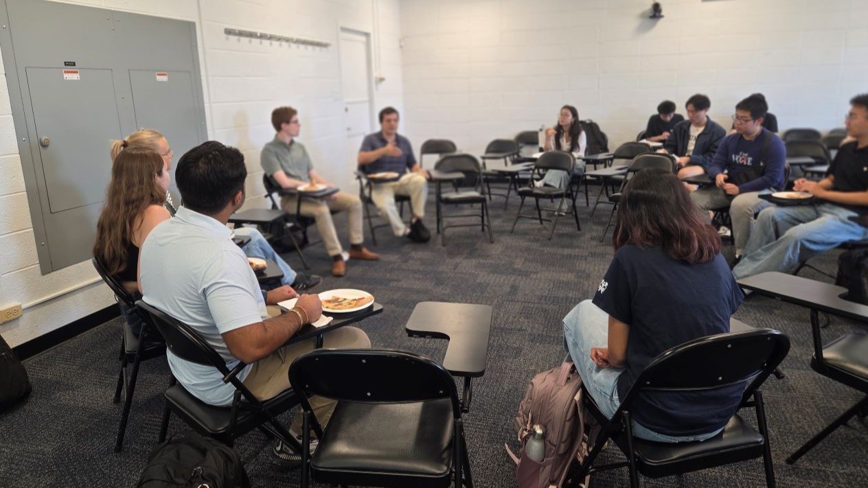 people in a classroom where desks are arranged in a circle