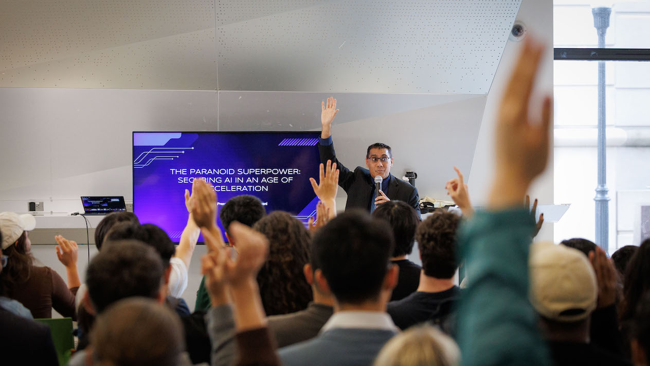 Neil Daswani raising his hand along with audience members