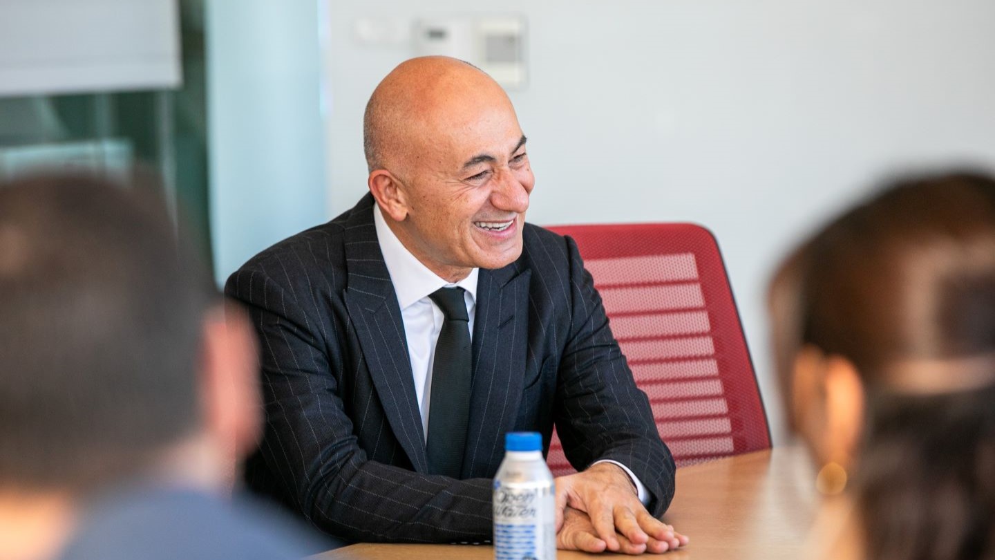 Erman Ilicak sitting at table, smiling