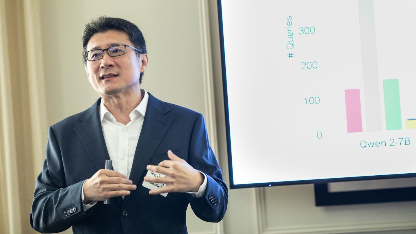 presenter standing in front of presentation displaying data with a bar graph