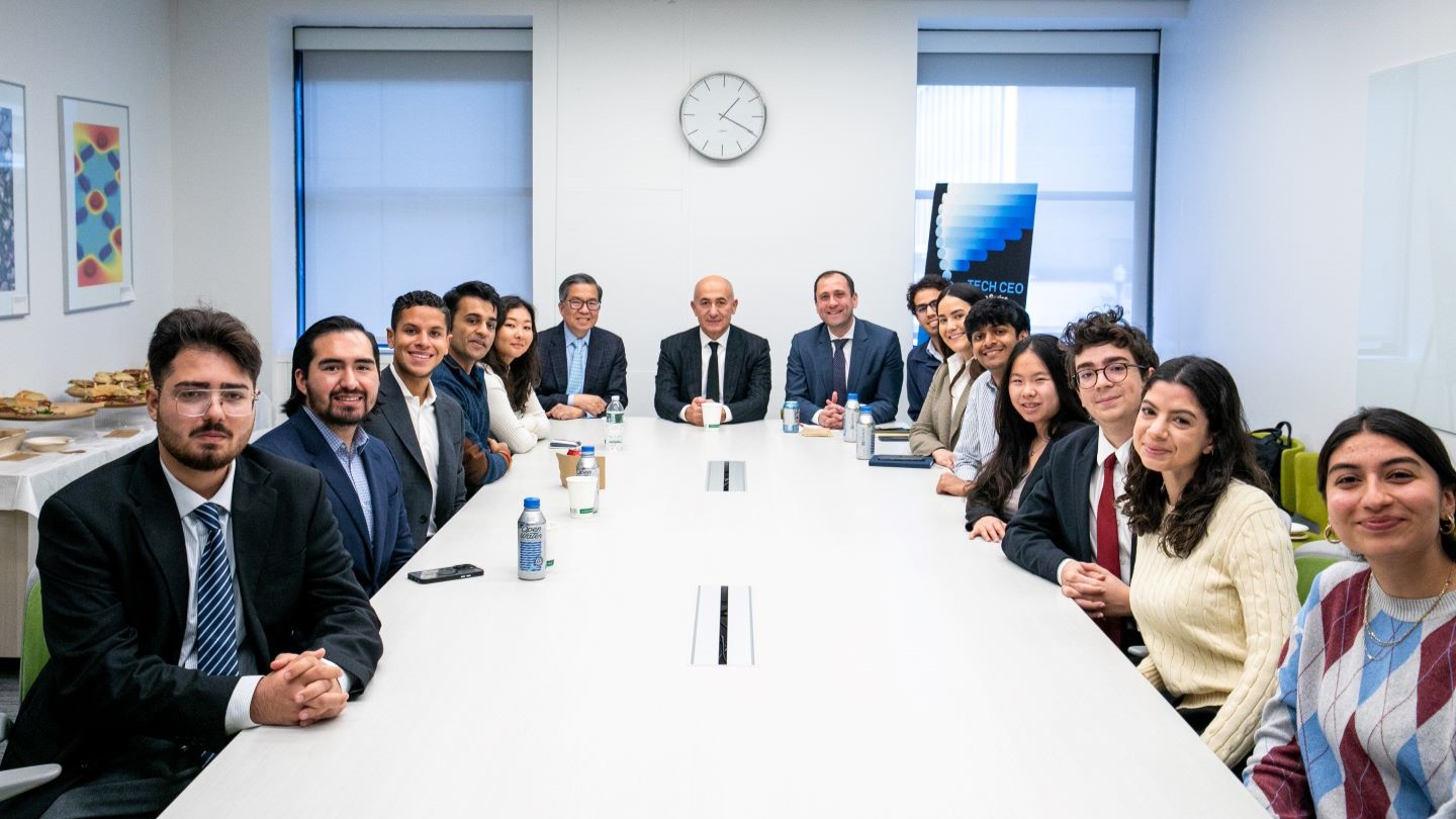 group photo of lecture series participants sitting at a conference table