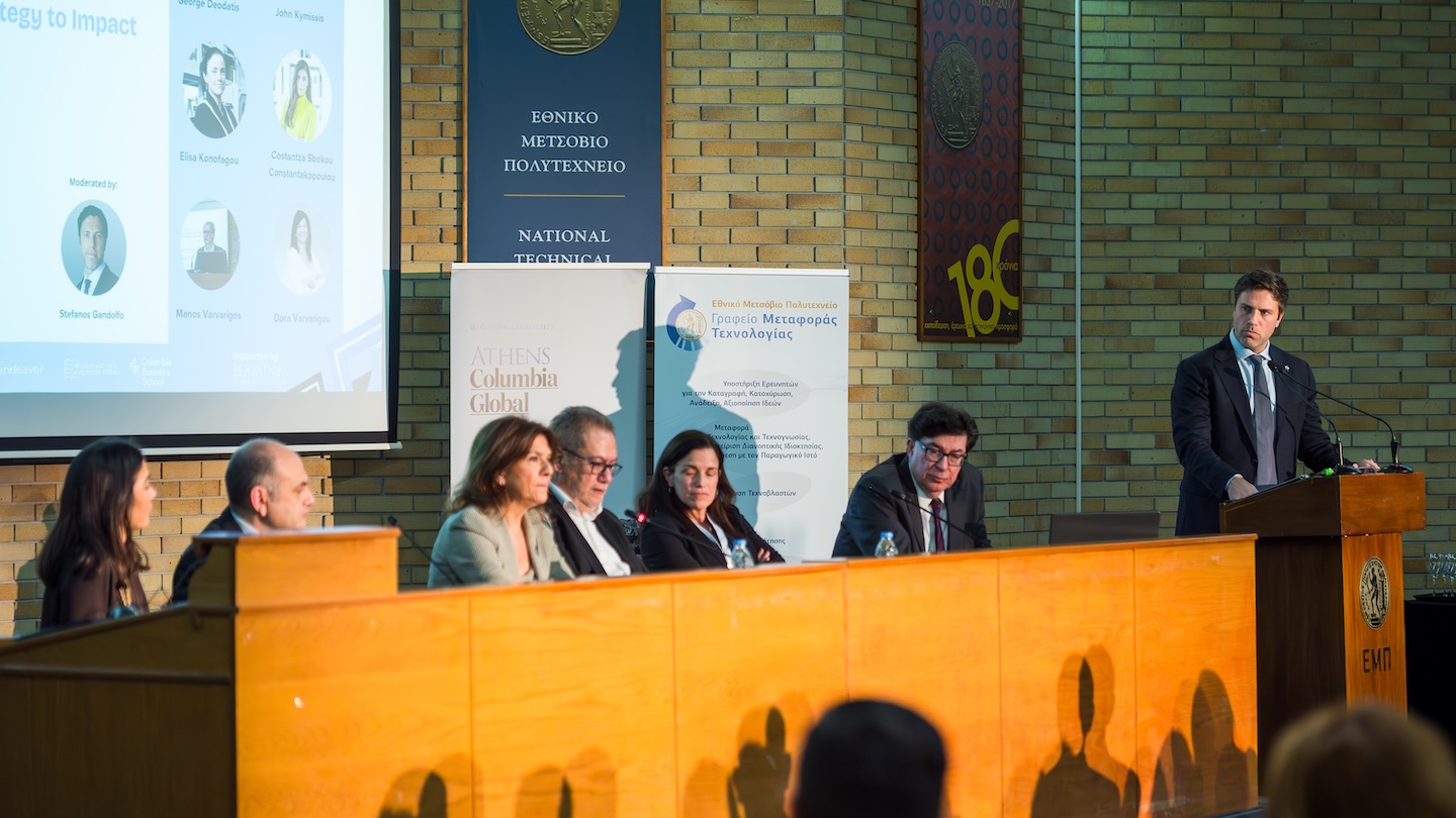 panel of speakers sitting in front of an audience