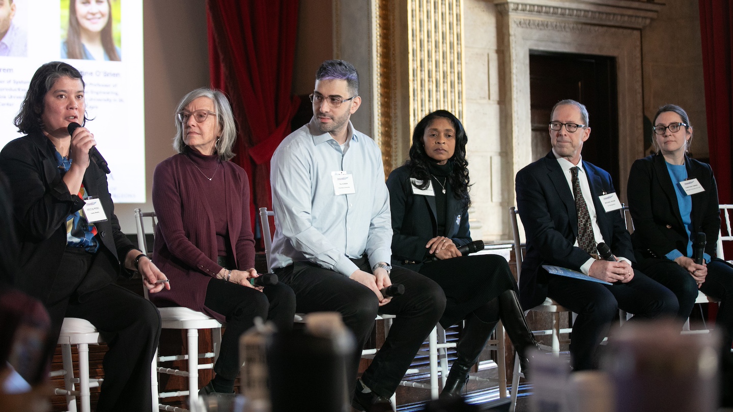 Women's health symposium speakers seated on stage