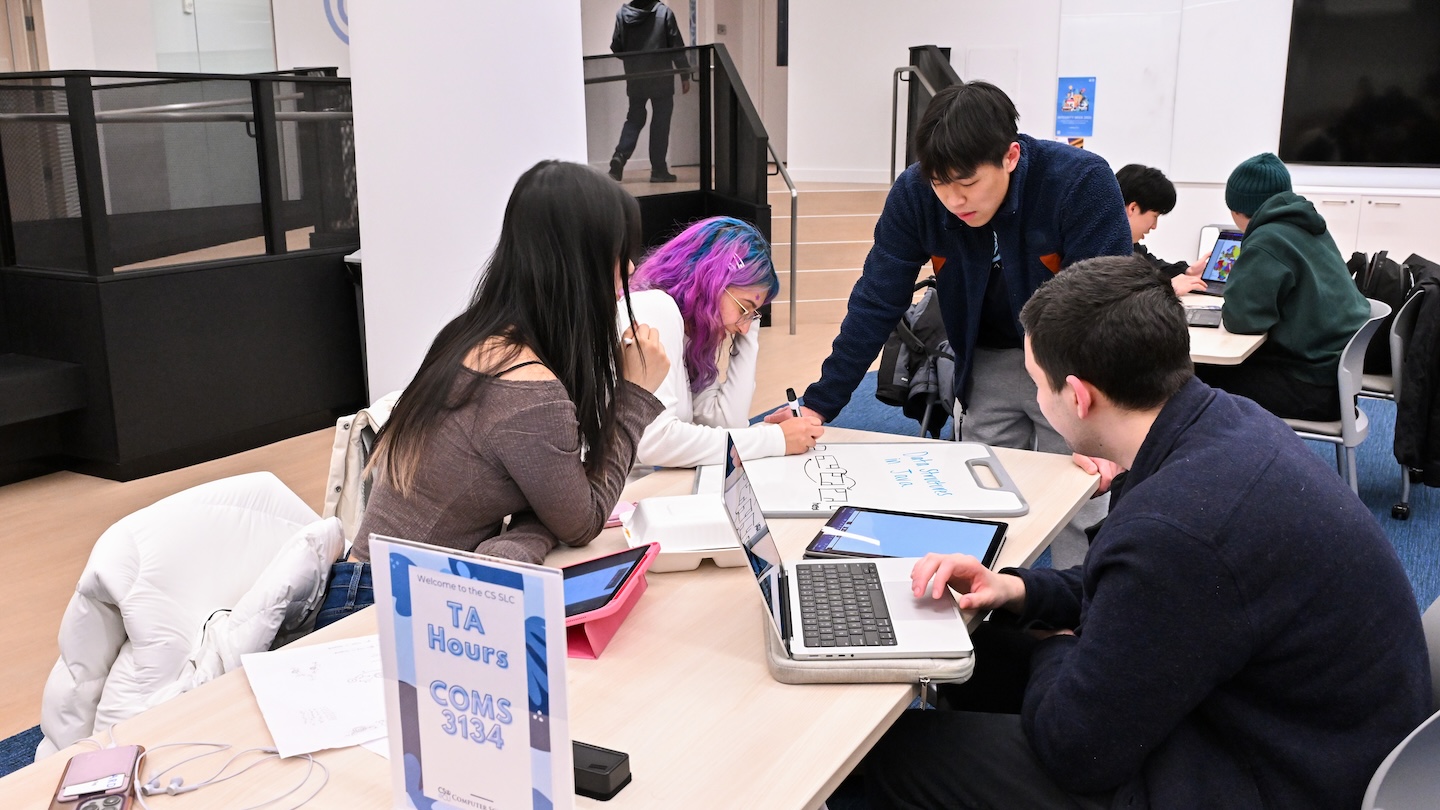 4 students with laptops sitting together at the CS learning center