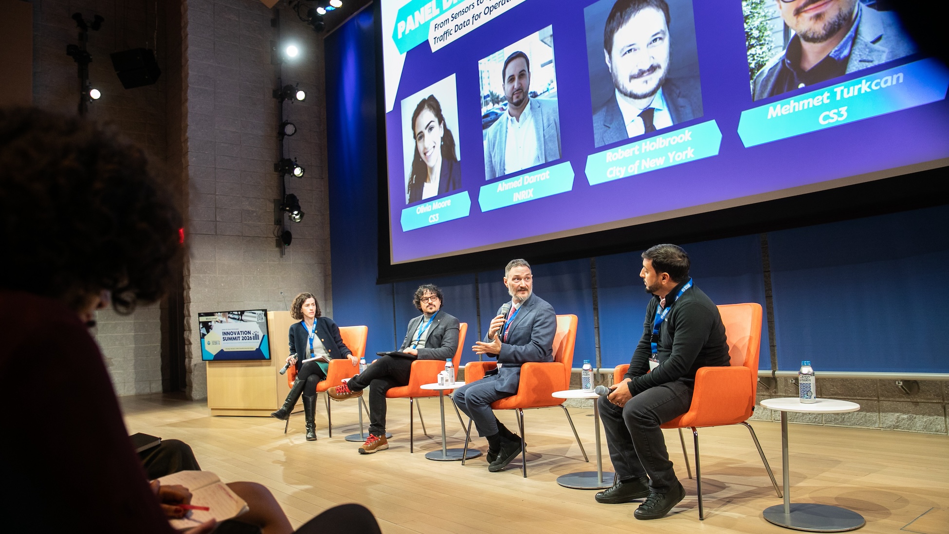 Four panelists sit on stage