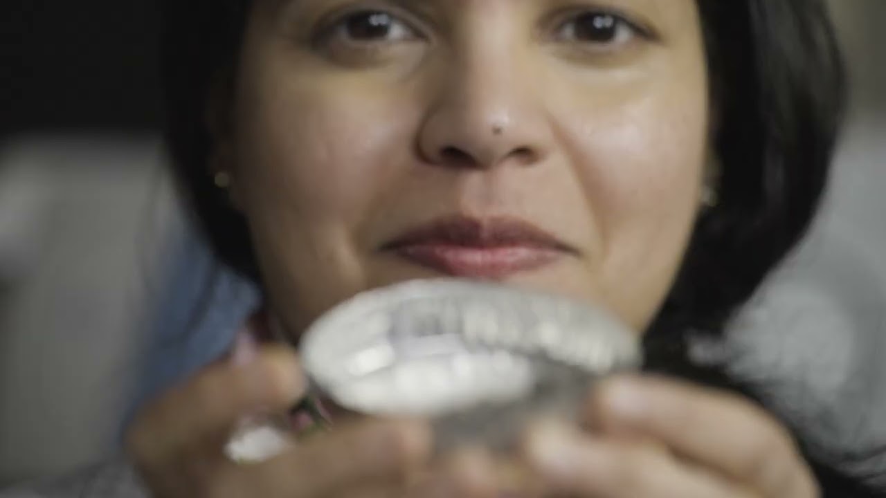 A close-up shot of a woman holding up container of alkaline residue