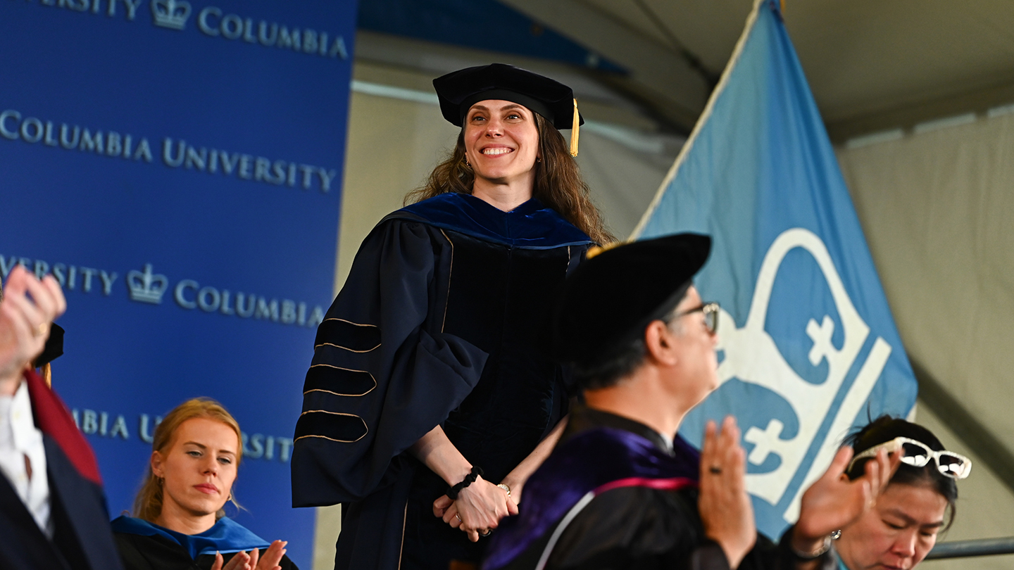 Lauren Marbella in graduation regalia standing among Columbia Engineering faculty during the 2026 Class Day ceremony