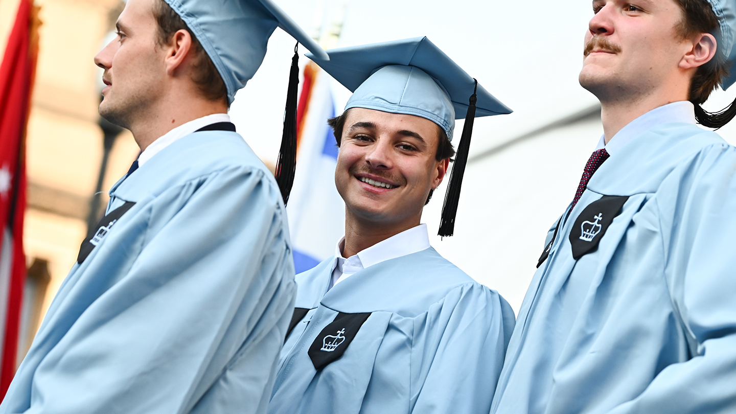 Three Columbia Engineering students in graduation regalia.