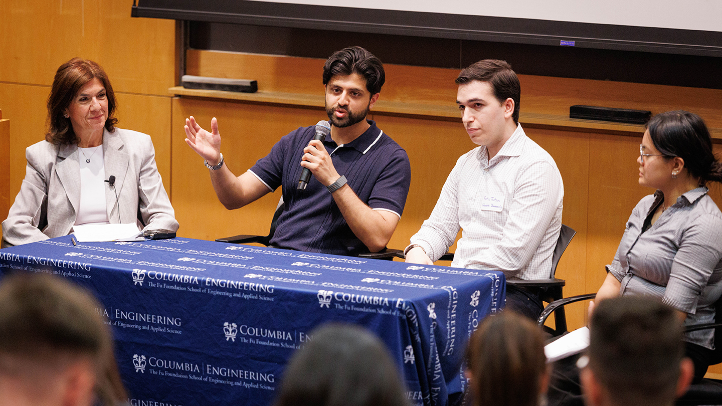 Panel discussion at a “Columbia Engineering” table; one panelist speaks into a microphone while others listen.
