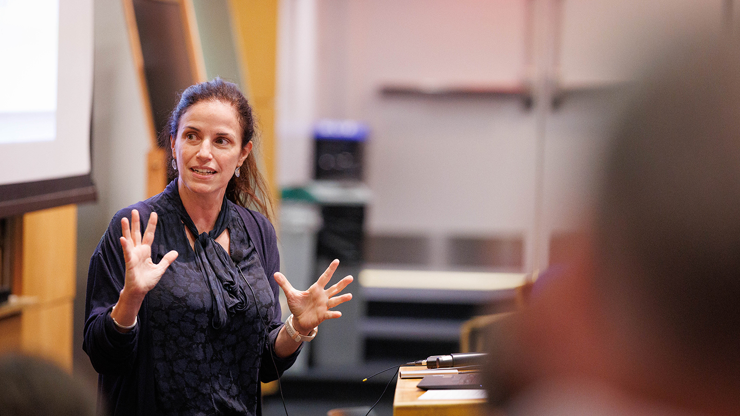 Elisa Konofagou presenter gestures with both hands while speaking at the front of a lecture room.