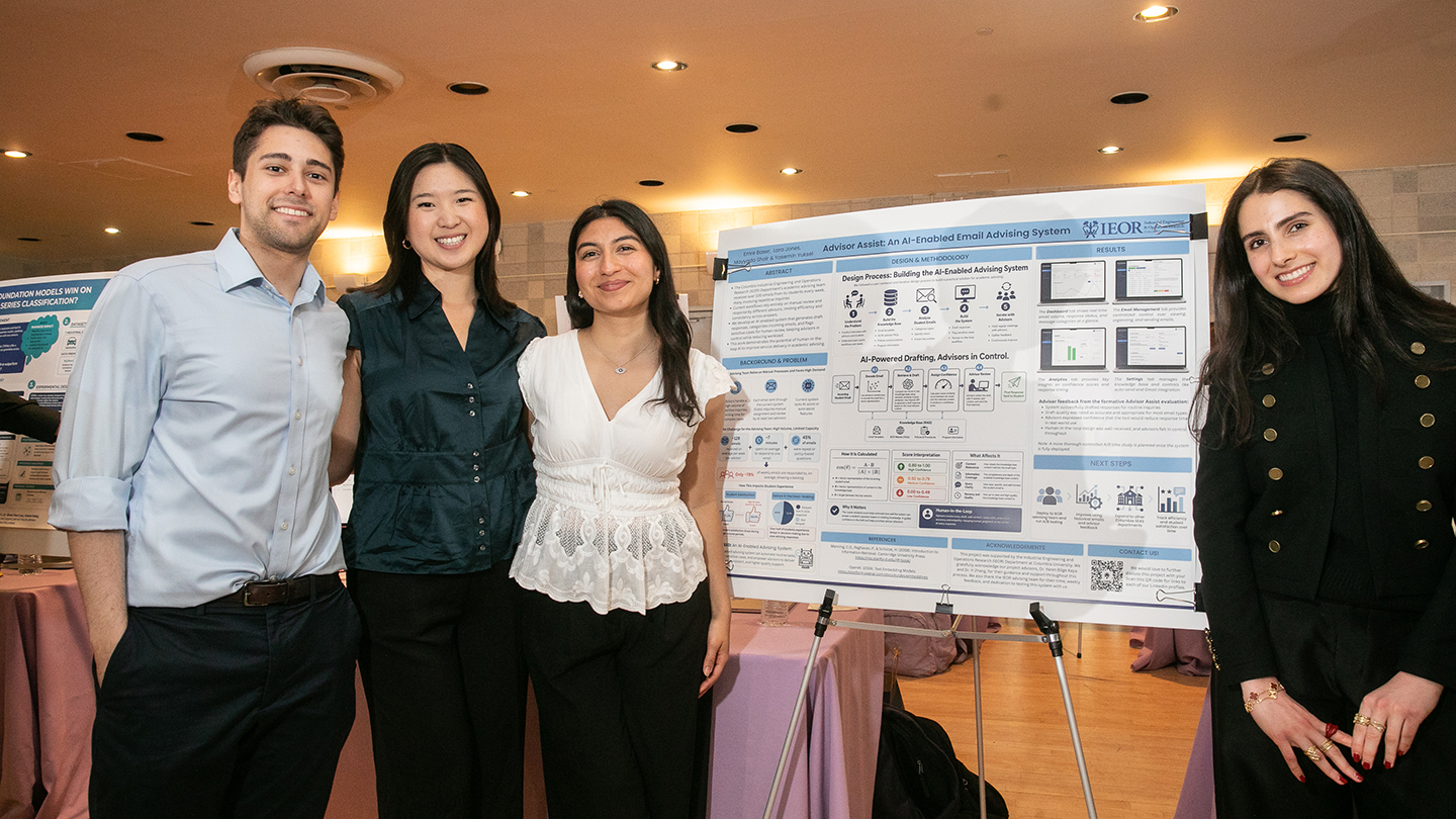Four students pose beside a research poster