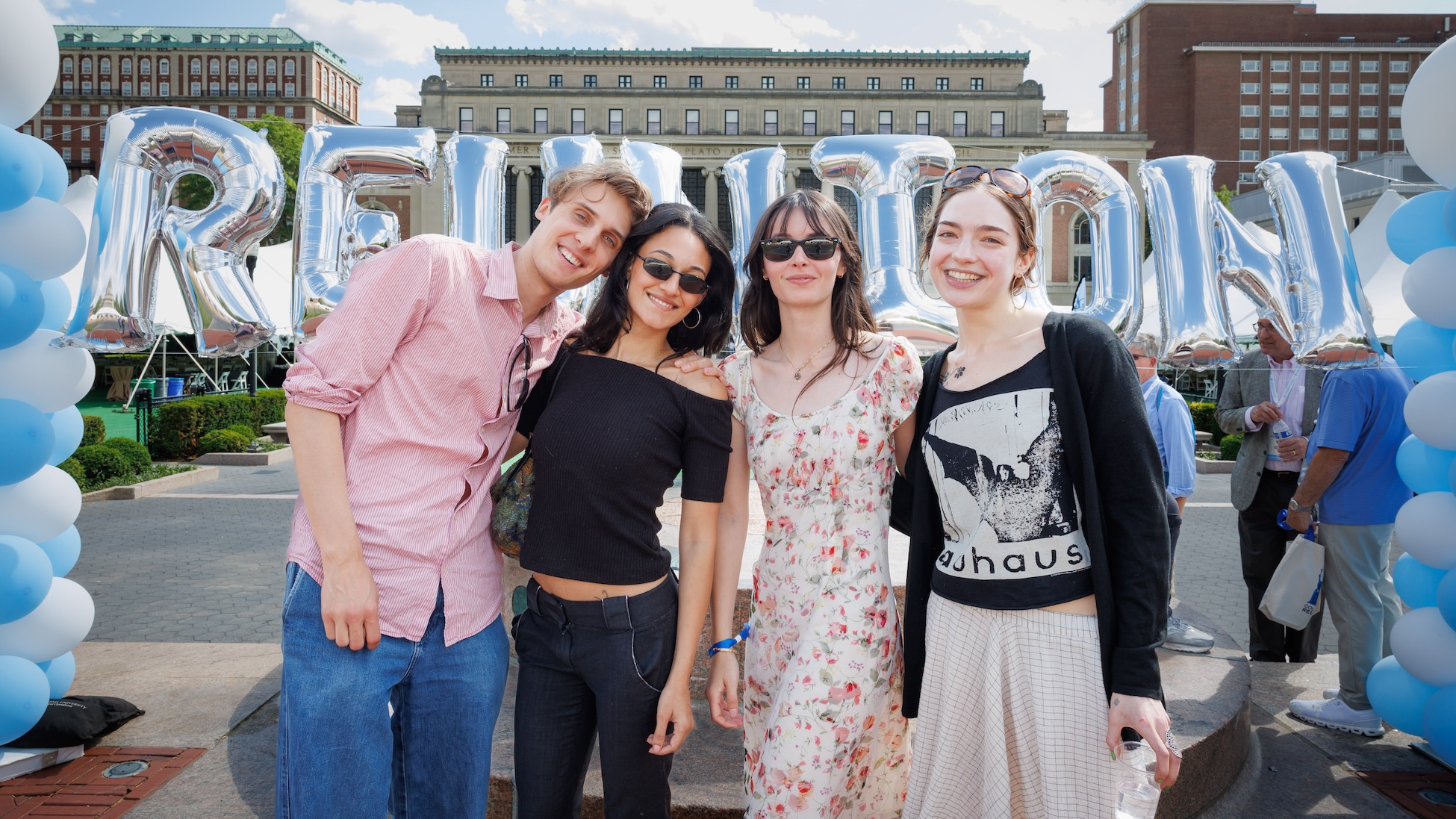  Four people smile for a photo in front of a large balloon during the Columbia Engineering reunion on campus.