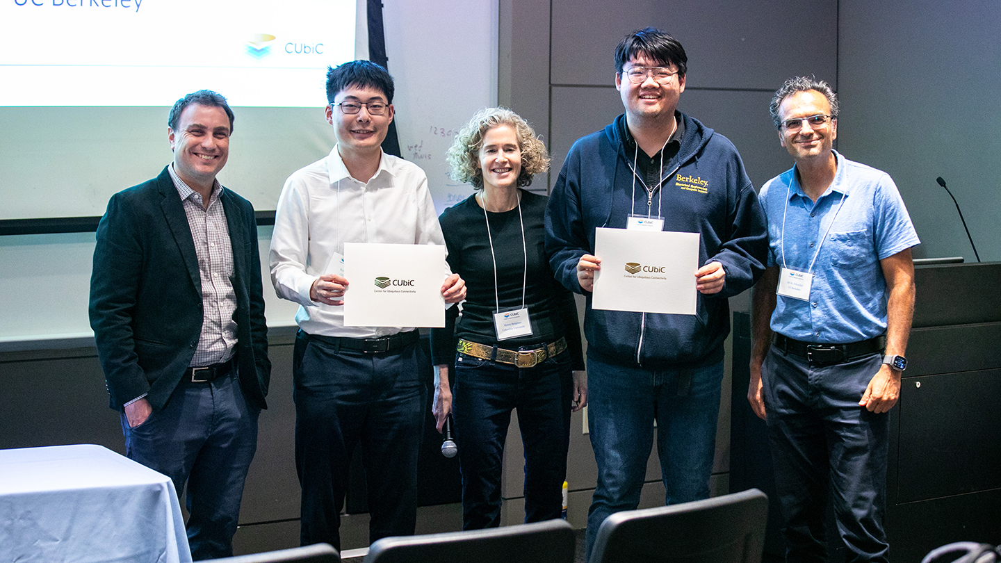 Ffve participants smiling in a lecture hall; two hold CUbiC certificates.