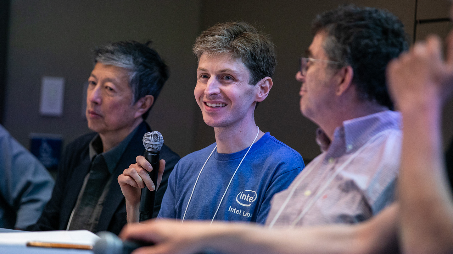  Cooper Levy smiles while holding a microphone during a discussion.