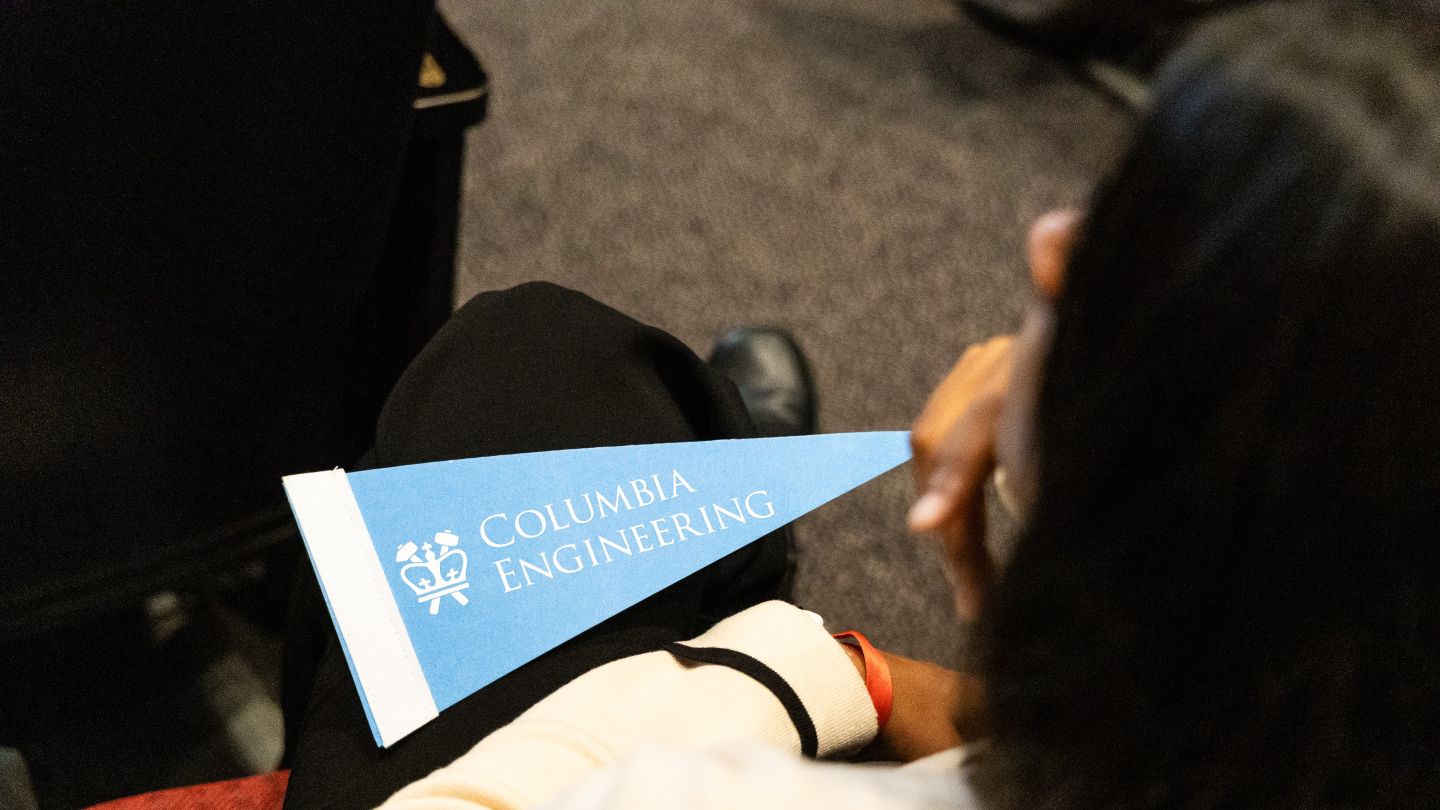 A blue Columbia Engineering pennant rests on an attendee's lap.