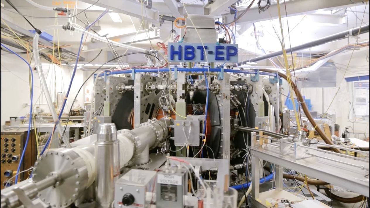 HB1-EP experimental equipment surrounded by cables and machinery in a laboratory