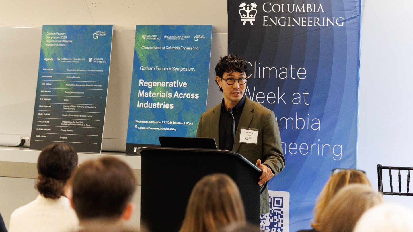 Sam Jung speaking to an audience from a podium at the Gotham Foundry symposium.