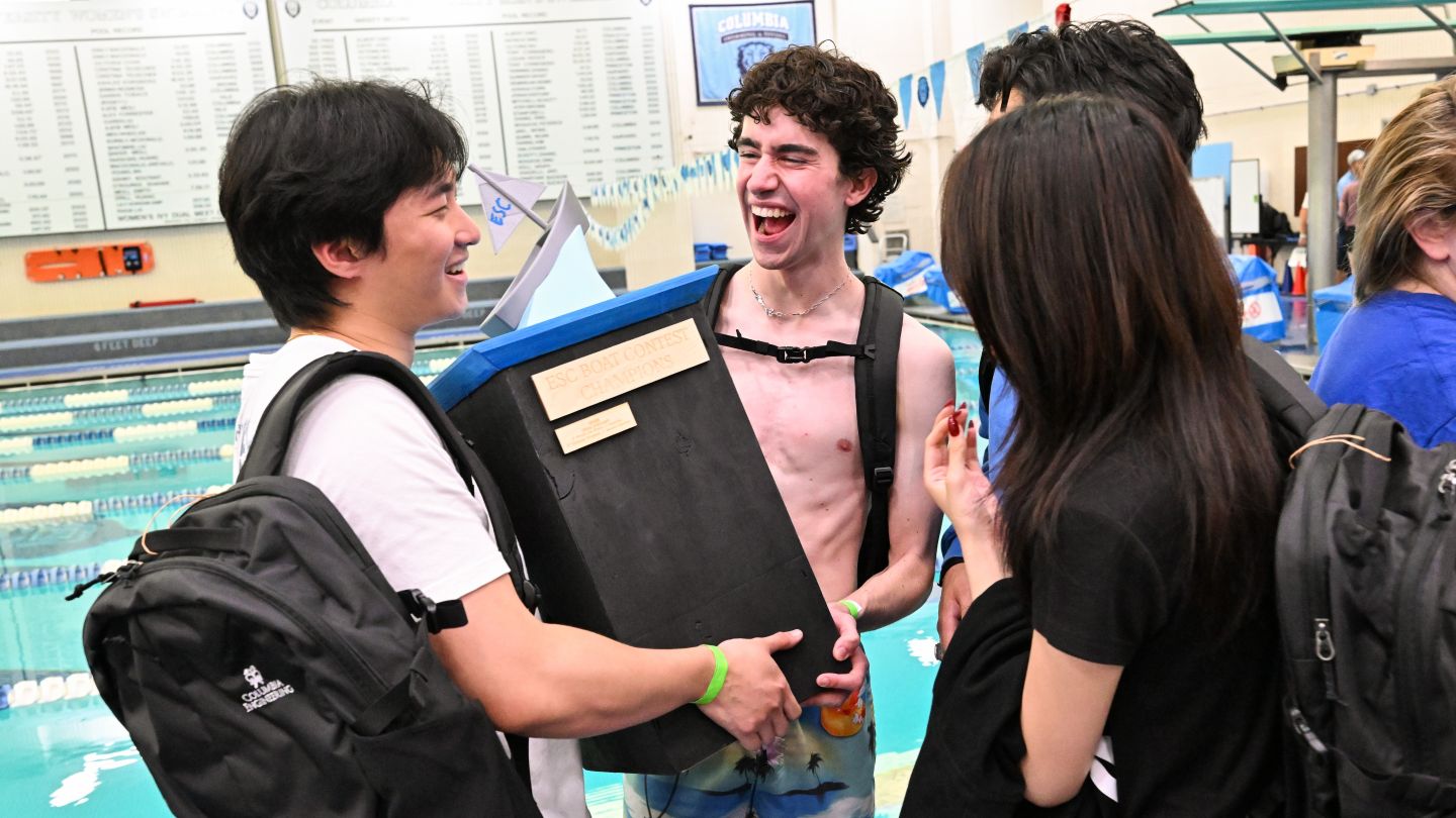 Members of The Promised Pirates celebrate while holding the ESC Boat Contest Champions trophy beside Uris Pool.