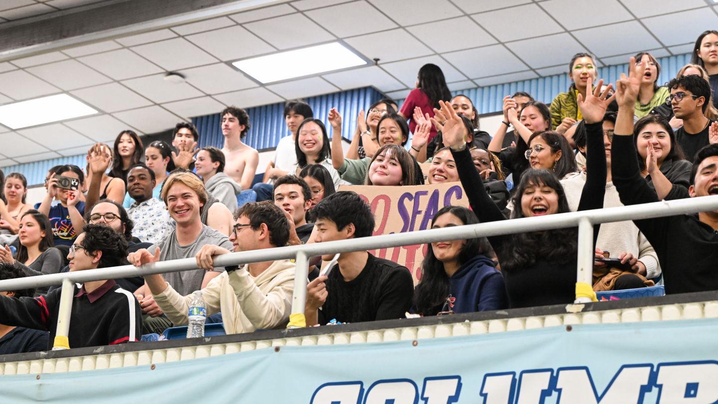 Columbia students cheer from the stands during the cardboard boat race at Uris Pool.