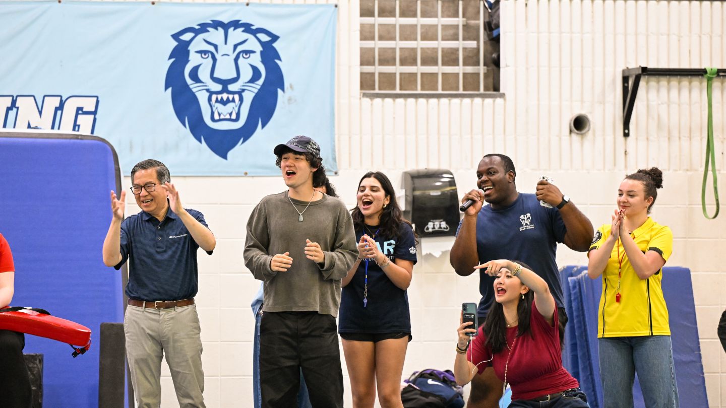 Dean Shih-Fu Chang and students cheer from the pool deck during the cardboard boat race at Uris Pool.